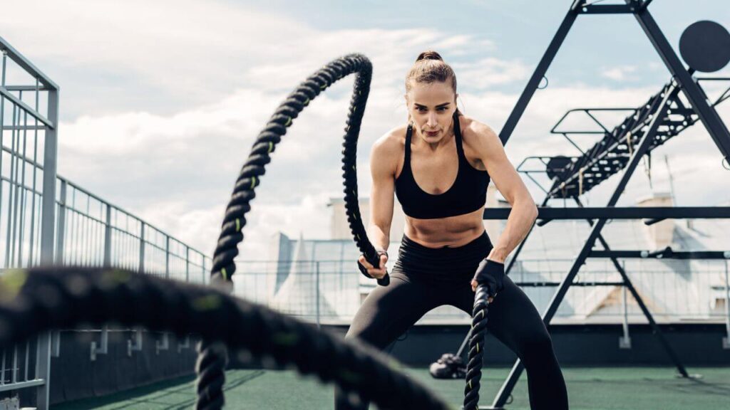 woman working out with battle ropes outside