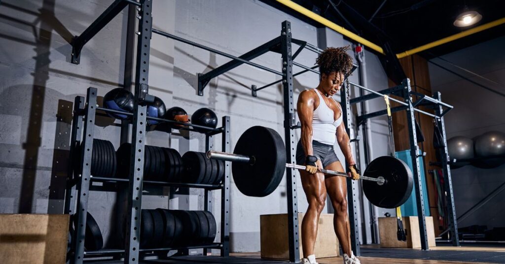 Woman performing deadlifts, one of the best functional exercises for whole-body strength and building muscles.