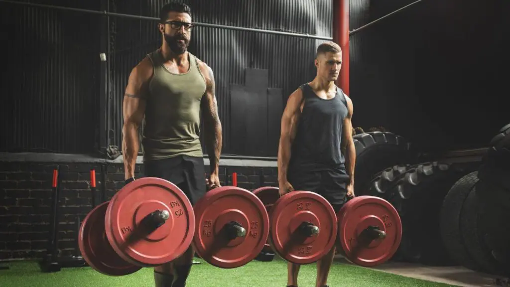 Two man perform farmers walk core exercise