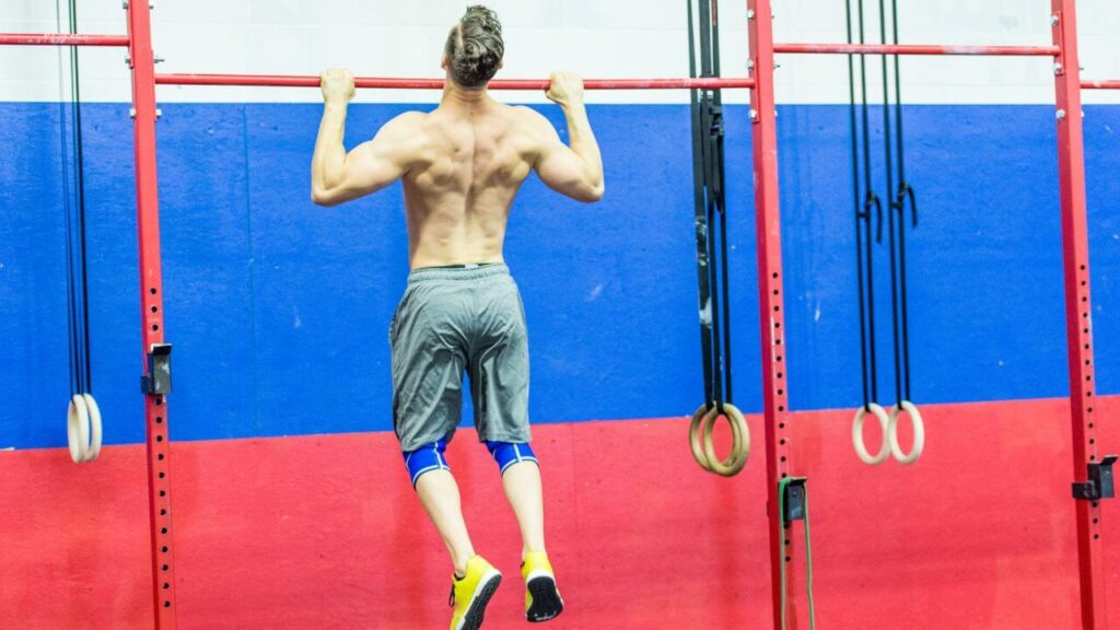 Man does pull-ups on a regular pull-up bar