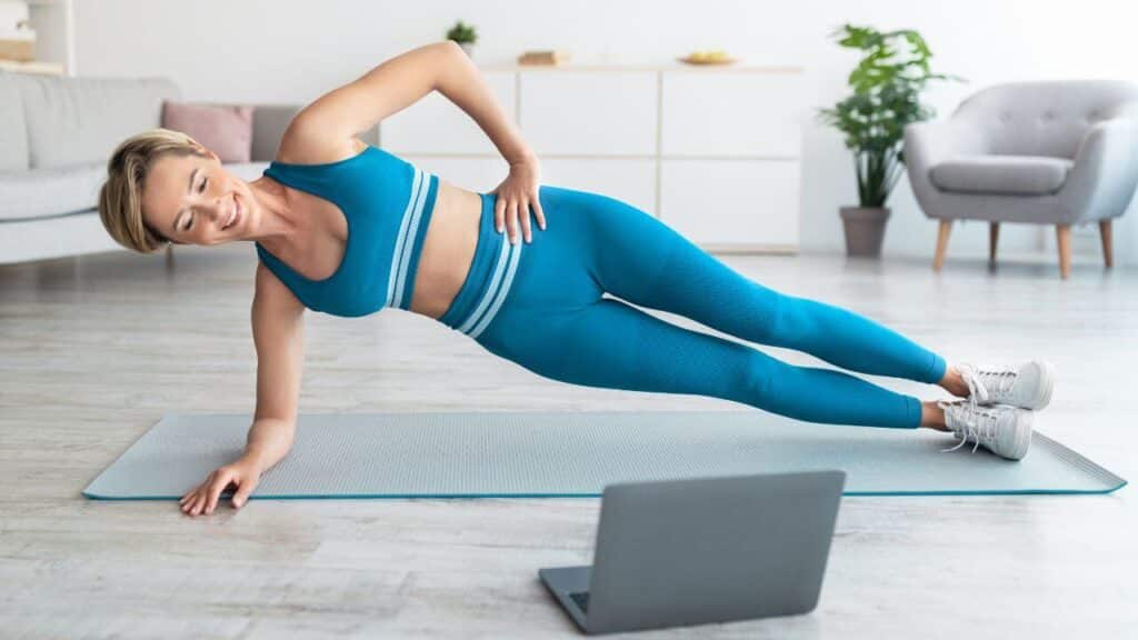 woman performis a side plank core exercise in the comfort of her home