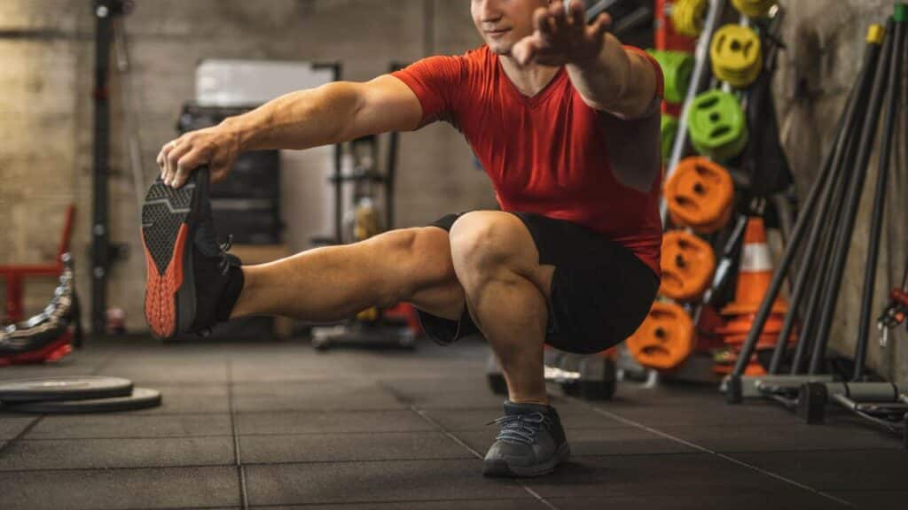 Man performing single leg squat in the gym