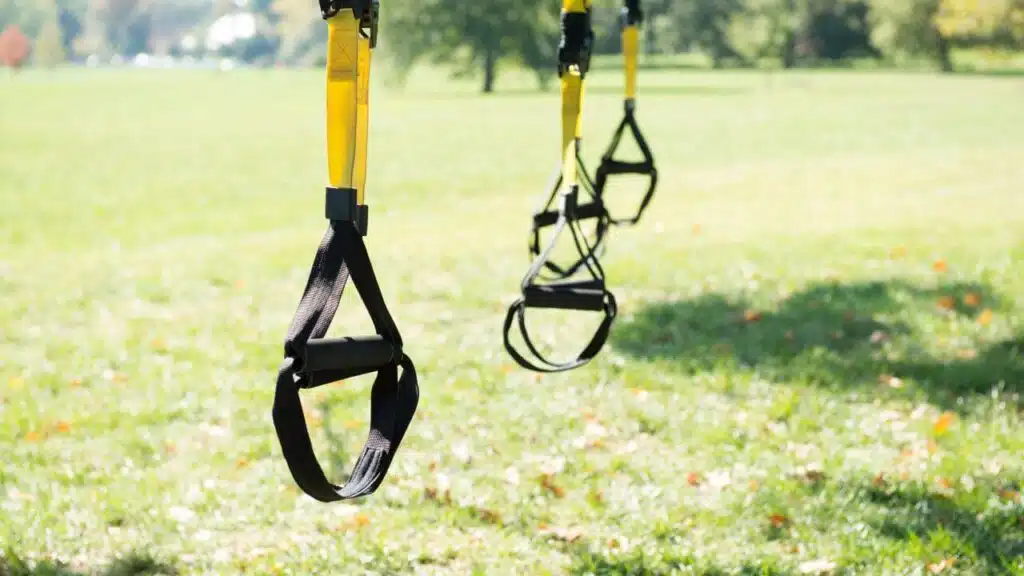 TRX(suspension system) placed outdoors, probably hanged on the tree branch.