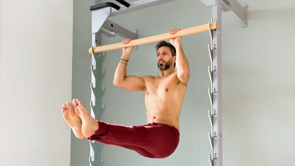 Man performs L sit pull ups.