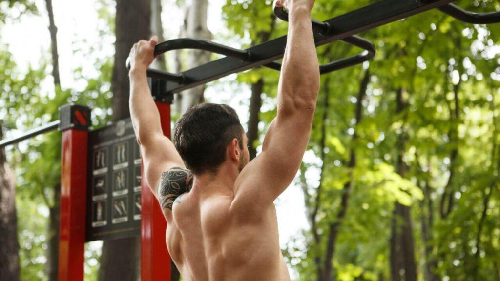 Man performs a wide grip pull up.