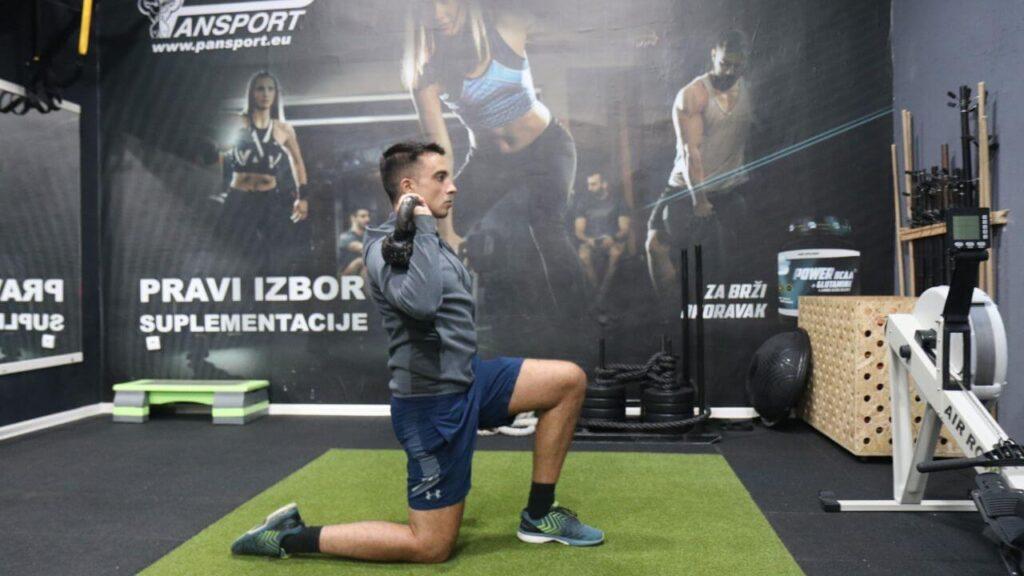 Radomir performs kneeling kettlebell press.