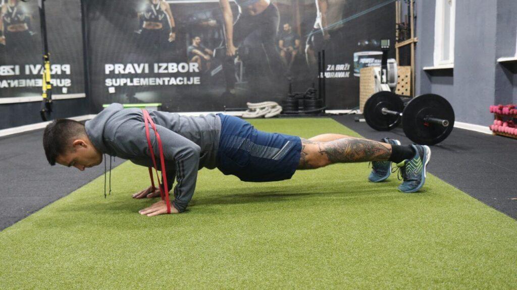 Radomir performs resistance band push-ups.