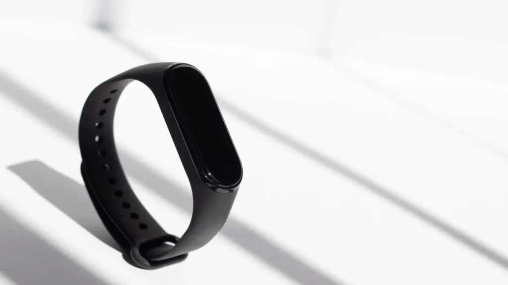 The image showcases a representation of a fitness tracker, how it looks like, its size, and its dimensions.