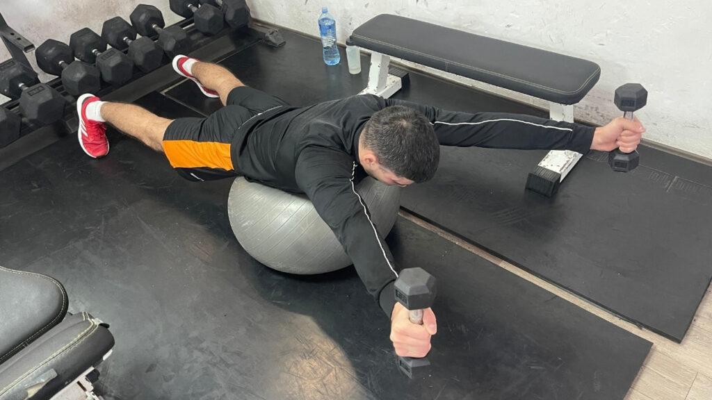 Vanja performs prone Y raises on a stability ball.