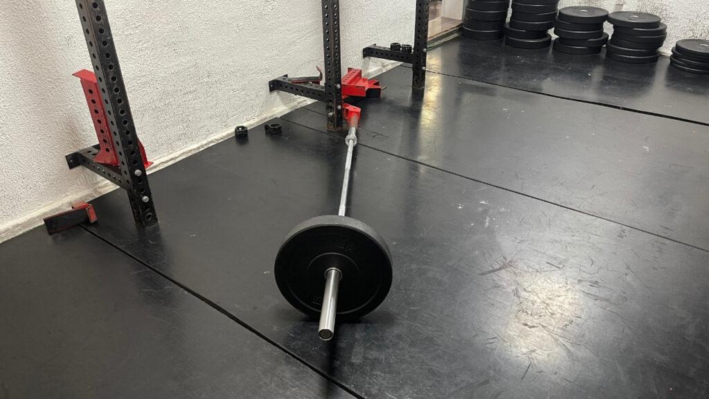 The image shows how to properly set up a landmine attachment and a barbell for landmine hack squats.