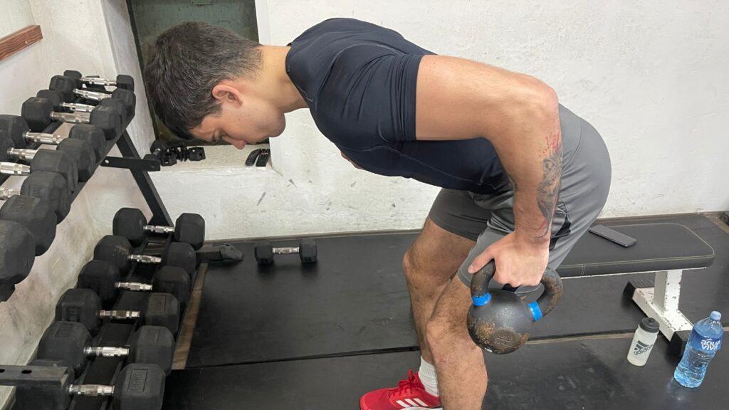 Vanja performs a single-arm, lat-row kettlebell alternative exercise in the bent-over position.